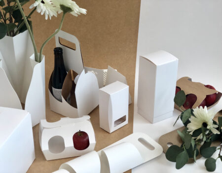 Emballasje av kartong til alle slags bruksområder, skreddersydd til kundens behov. Eksempler på esker uten trykk, med blomster, epler og glassflaske.